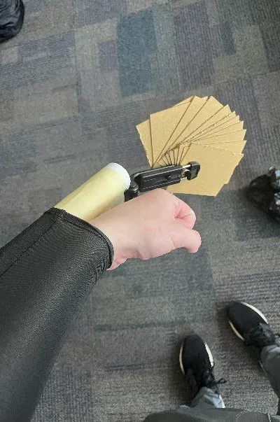 A person holding the adaptive card holder with cards fanned outward
